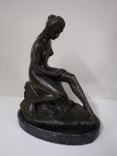 A bronze figure of a nude female on marble base