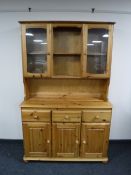 A pine triple door dresser with glazed doors