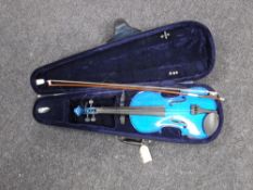 A violin and bow in case together with a music stand and a crate containing violin music books