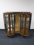 A mid 20th century shaped walnut display cabinet