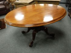 A Victorian mahogany oval breakfast table on carved pedestal raised on ceramic castors,