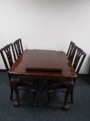 An early 20th century mahogany wind-out dining table on claw and ball feet together with a set of