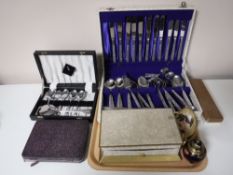 A tray containing boxed table cutlery, canteen of stainless steel cutlery,