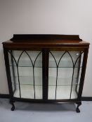 A mahogany display cabinet on claw and ball feet