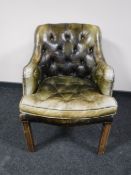 An early 20th century green button leather chesterfield armchair