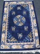 A fringed Chinese rug on blue ground, 182 cm x 122 cm.