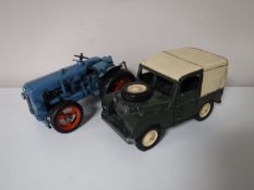 A contemporary metal Fordson tractor together with a land rover