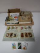 A tray containing a quantity of cigarette and tea card albums with cards
