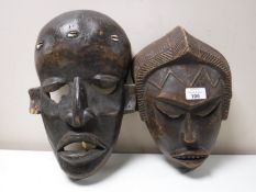 A pair of African carved wooden masks.