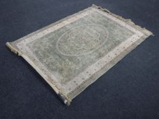 A machine made rug of Indian design, on green ground,