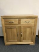 A light oak two drawer side cabinet,