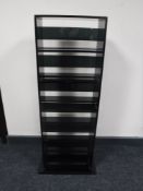 A contemporary black glass CD stand