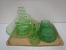 A tray containing a green glass four piece dressing table set,