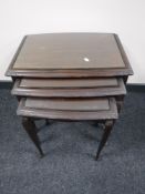 A nest of three mahogany glass topped tables and a book table
