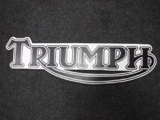 A hand painted Triumph motorcycles advertisement on board