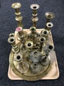 A tray containing a quantity of brass candlesticks,