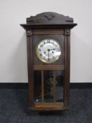 An early 20th century oak wall clock with silvered dial