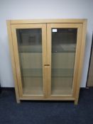 A contemporary oak double door display cabinet
