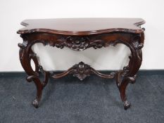 An Eastern carved mahogany shaped hall table