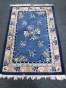 A fringed Chinese rug on blue ground, 184 cm x 122 cm.