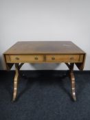 An inlaid mahogany Victorian style sofa table fitted two drawers