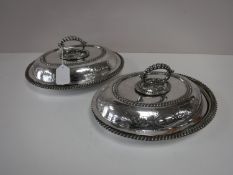 A pair of plated entree dishes with covers