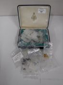 A box of various loose gemstones including amethysts, garnets, citrines,