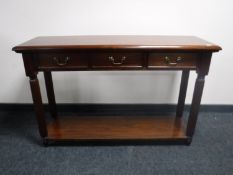 A reproduction mahogany hall table fitted three drawers with undershelf