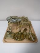 A tray containing brass candle holders, brass trivets,