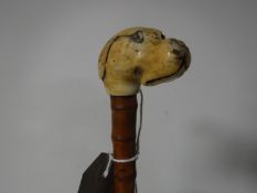 A carved bone miniature dogs head walking stick,