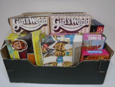 A box containing vintage games and toys, including two Girls Worlds Hair Styling Models,