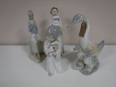 A Nao figure of a boy carrying books together with three other Spanish figures