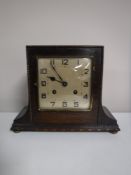 An early twentieth century oak mantel clock with pendulum and key