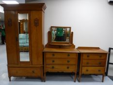 An Edwardian satin walnut three piece bedroom suite, comprising of a mirrored door wardrobe,