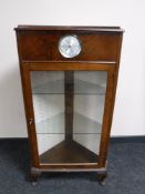A mid 20th century walnut corner display cabinet fitted with a Smiths clock