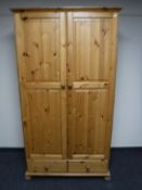 A pine double door wardrobe fitted two drawers