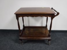 A stained pine two tier serving trolley