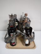 A tray containing six contemporary wine bottle holders, together with three bottles of red wine,