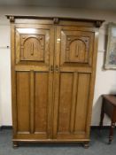 An early twentieth century panelled oak double door wardrobe,