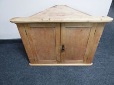 A pine double door hanging corner cabinet