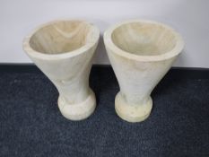 A pair of conical sandstone vases