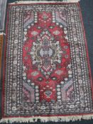 An Afghan rug of Caucasian design, on red ground,