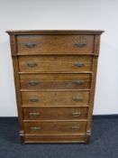An Edwardian carved oak six drawer chest
