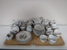 Two trays of two Japanese tea services one with an image of a Geisha