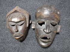 A pair of African carved wooden masks.