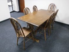 An oak refectory dining table, together with a set of six Windsor chairs, one carver,