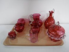 A tray of eight pieces of cranberry glass ware