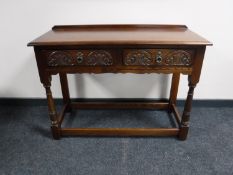A carved oak hall table fitted two drawers