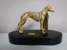 A gilt bronze greyhound figure on wooden plinth