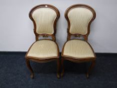 A pair of antique mahogany dining chairs upholstered in a gold striped fabric